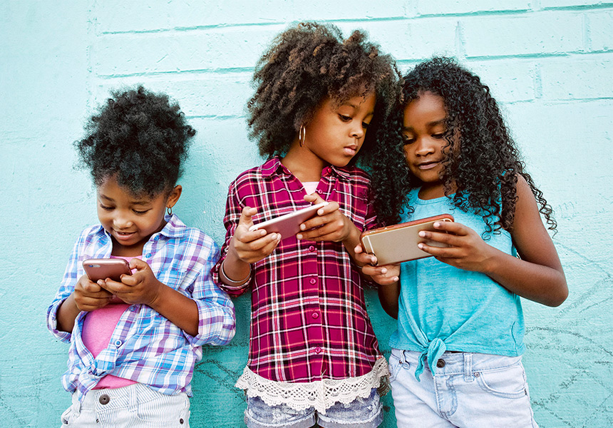Little girls looking at individual mobile devices