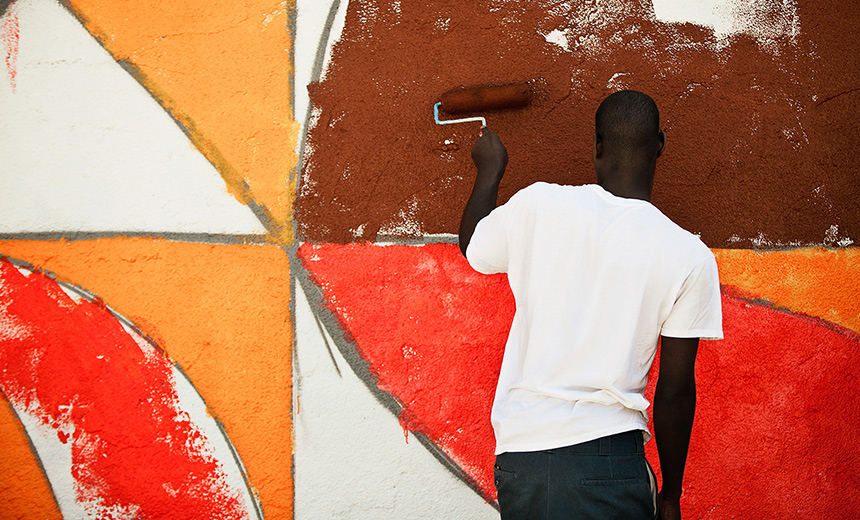 A man painting a colorful mural
