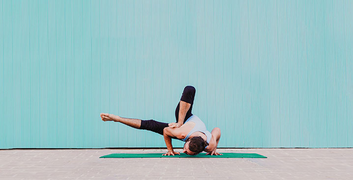 Man doing yoga pose on blue background