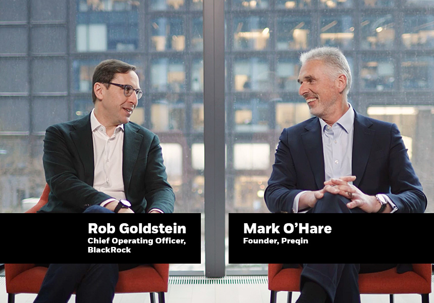 Rob Goldstein and Mark O'Hare chatting and sitting down in two red chairs.