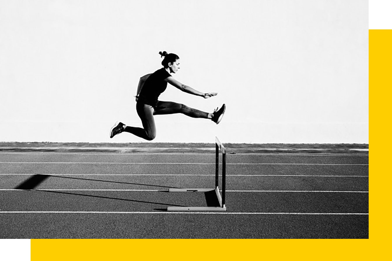 Female athlete leaping over a hurdle