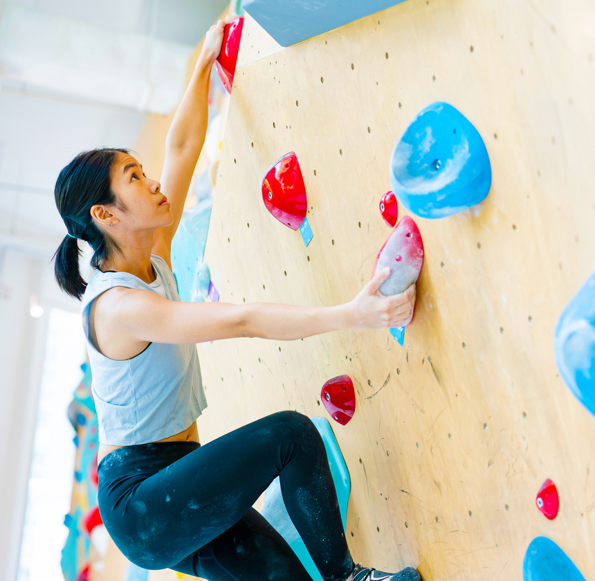 woman climb boulder wall