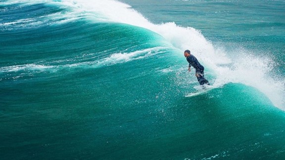 man surfing through sea waves