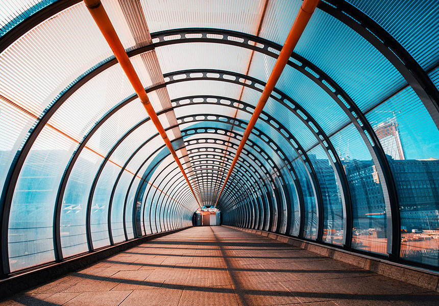 A walking path tunnel through an urban environment