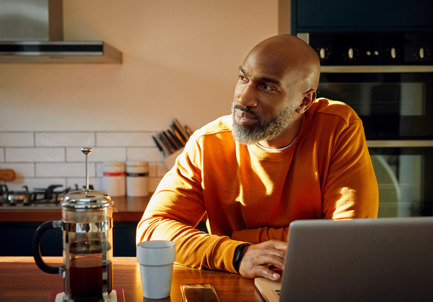 A man working on his laptop in his kitchen