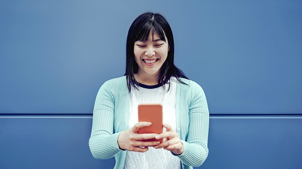 Young woman smiling at mobile phone