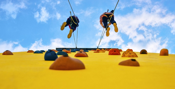 Two rock climbers scaling a wall