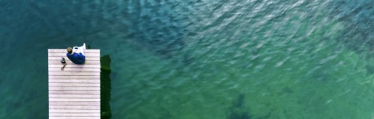 Image of person sitting near beautiful lake