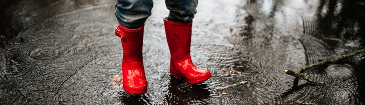 red rainboots standing in a puddle