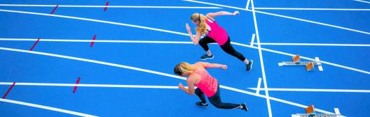 Women racing on a track, symbolizing empowerment and strength in the pursuit of financial independence