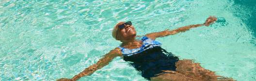 Woman laying in a pool representing the benefits of lifetime income for retirement