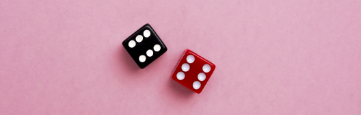 Red and black gaming dices on pink background