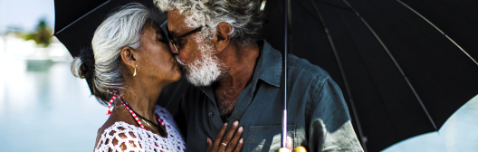 Senior couple kissing under umbrella
