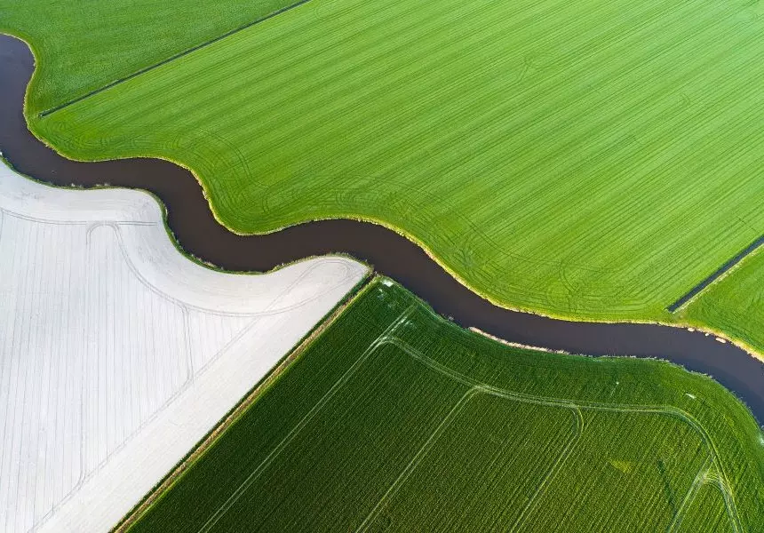 Stream flowing through green field