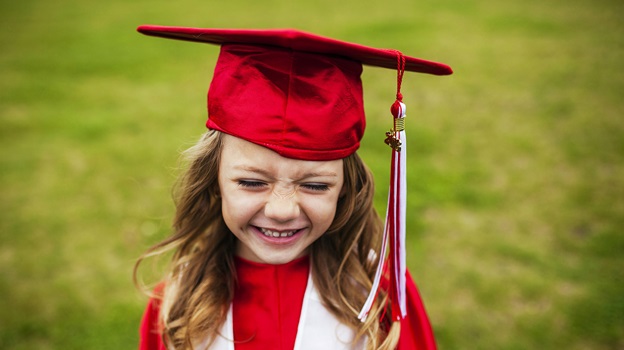 Child wearing a red graduation cap