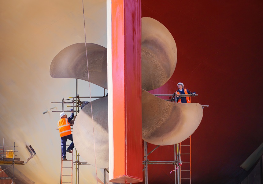 Construction workers operating a large propeller