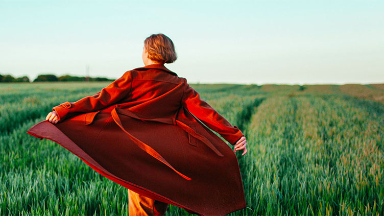 Frau mit rotem Kleid in einem Feld