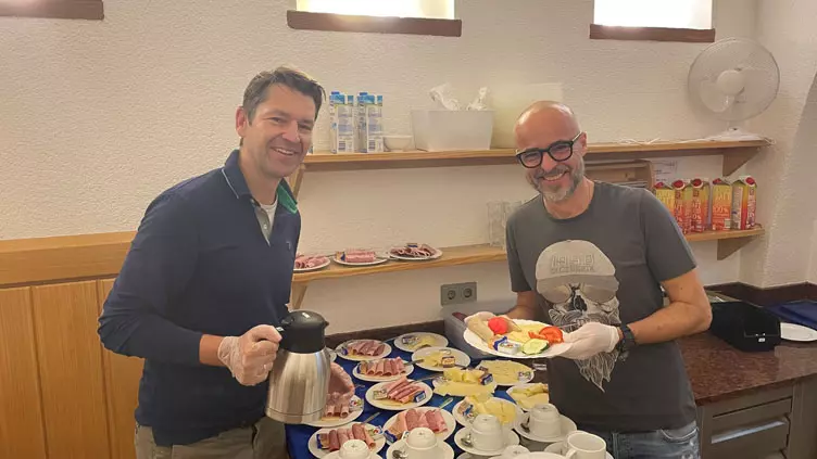 Zwei Kollegen während sie Frühstück beim Franziskustreff zubereiten