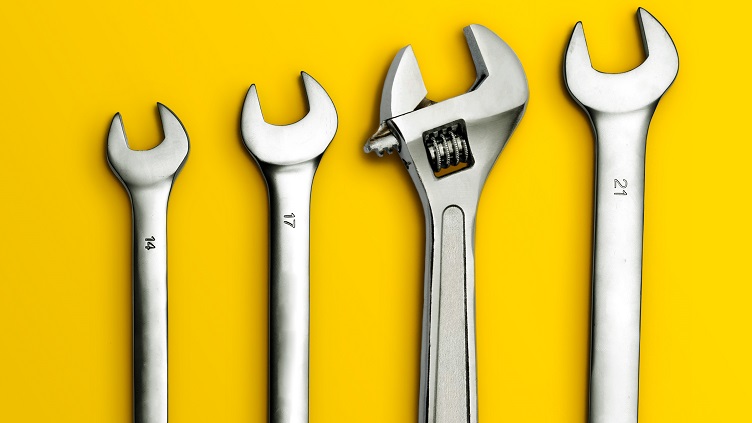 Four wrenches of increasing sizes on a yellow background