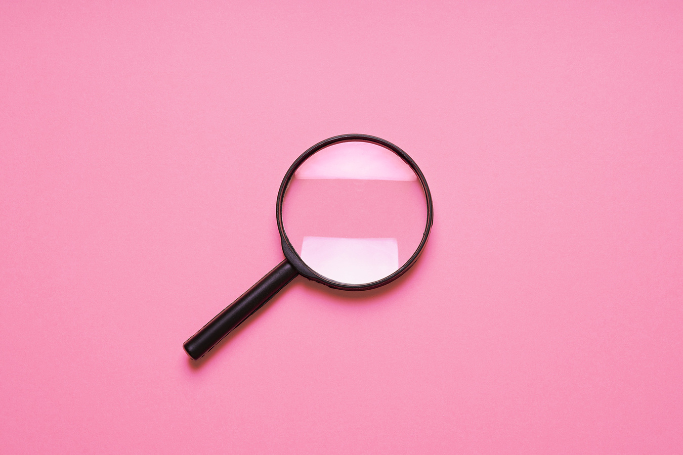 Magnifying glass on pink background