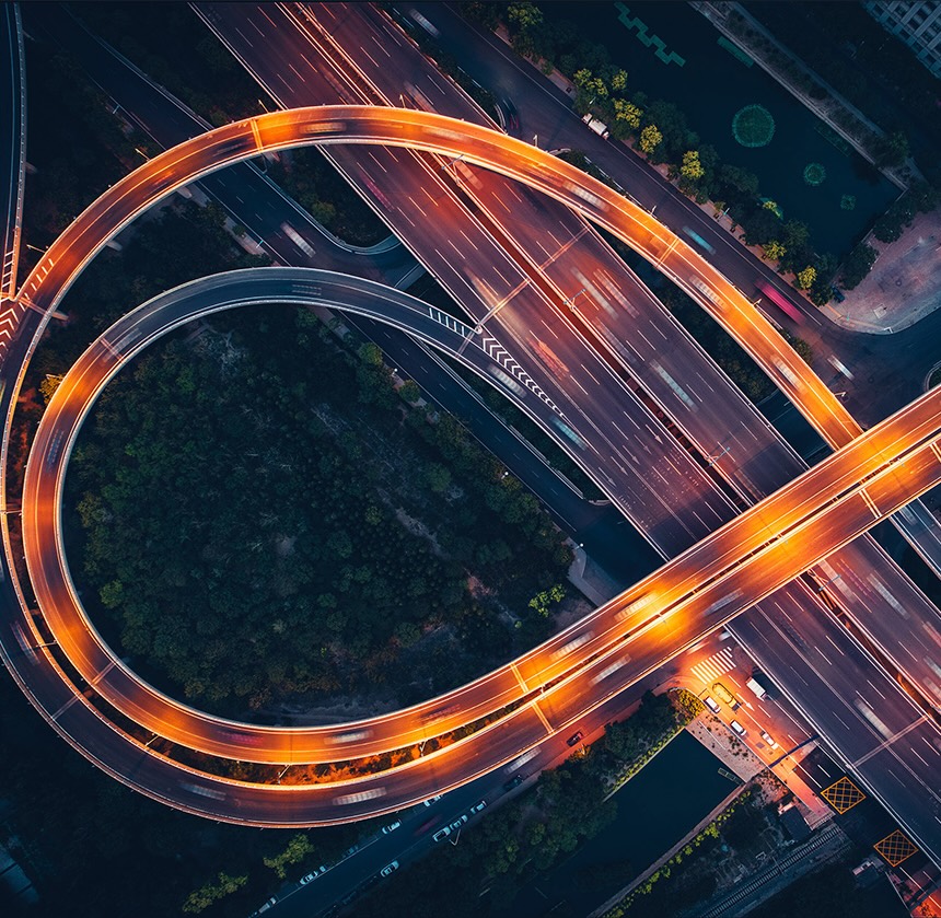Widok z lotu ptaka na jasno oświetlony węzeł autostradowy nocą
