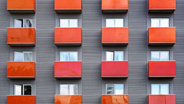 image o the side of a building with red balconies.